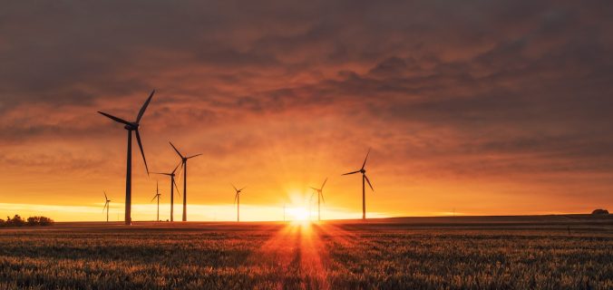 windmill on grass field during golden hour