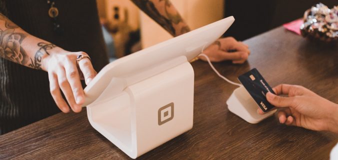 person holding white POS machine
