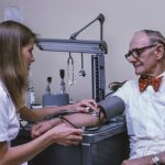 a doctor examining a patient's ankle with a stethoscope