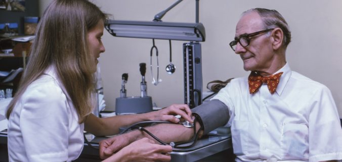 a doctor examining a patient's ankle with a stethoscope